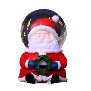 Boule à neige Père Noël avec base en résine et effet lumineux étoilé à l'intérieur