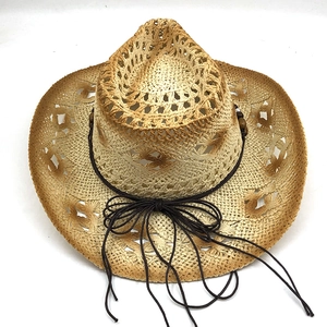 Dettaglio di un cappello da cowboy intrecciato con motivi traforati e nastro di perline