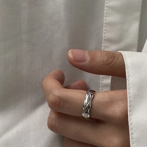 Detailed close-up of a silver rhombic textured ring with star accents on finger
