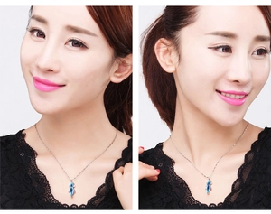 Close-up of model wearing a rhonbus blue topaz pendant on a silver necklace chain
