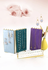 Detail of four colorful velvet jewelry display stands with gold metal frames and hooks