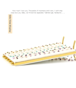 Detail view of gold chain necklaces with colorful gemstones on a jewelry display stand