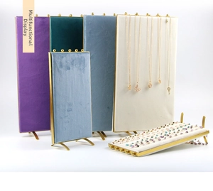 Close-up of luxury velvet jewelry display boards with gold metal frames and hooks