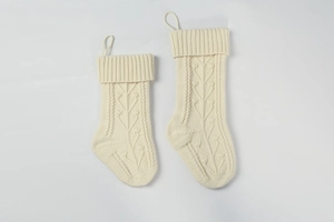 Detail of cream cable knit Christmas stockings set in two sizes for festive decoration