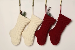 Close-up of four cable knit Christmas stockings in cream and deep red hanging on hooks