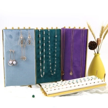 Vertical velvet jewelry stands in teal, green, and purple with white ring display tray