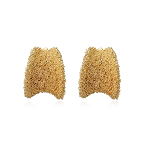 Close-up of golden irregular textured geometric earrings with vintage brushed finish
