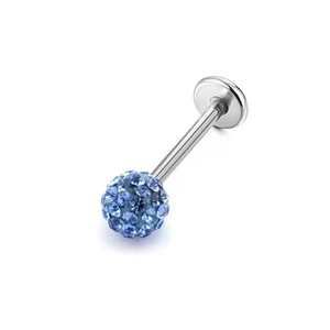 Macro shot of silver body piercing stud with a sparkling blue crystal pavé ball on white