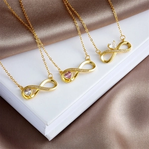 Infinity gold necklace with heart zircon pendant on elegant satin backdrop