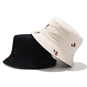 Detail shot of cherry embroidery on black and beige canvas reversible sun hats