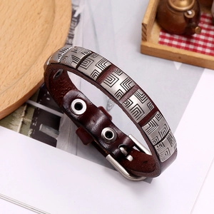 Detail of dark brown leather punk bracelet with engraved silver metal geometric pattern