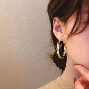 Golden C-shaped hoop earrings with embedded diamonds and geometric hollow design