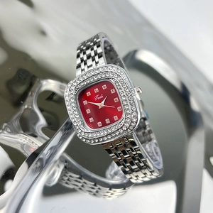 Close-up of diamond-bezel women's watch with red dial and silver stainless steel strap
