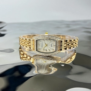 Elegant gold tonneau quartz watch for women with emerald dial and crystal accents