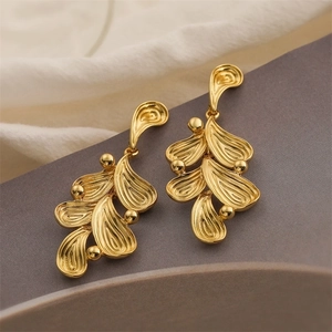 Close-up of 18K gold plated leaf-style drop earrings with intricate textured details