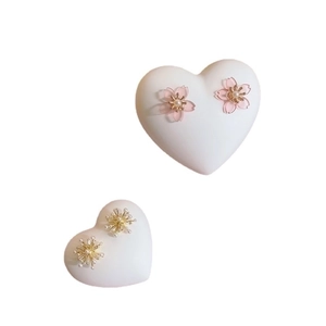 Pink sakura and gold flower stud earrings with pearls on heart shaped jewelry stands