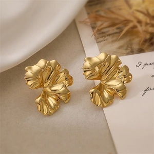 Detail shot of vintage 18K gold plated bow earrings on a white cloth and cards