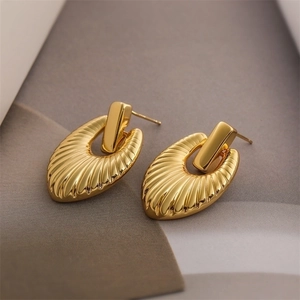 Macro view of 18K gold plated ribbed oval stud earrings with elegant metallic texture