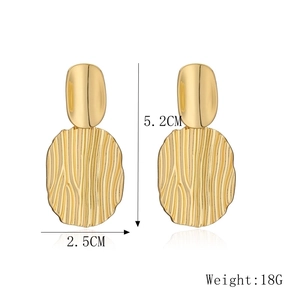 Detail view of gold heart drop earrings with vertical stripes, size 5.2cm by 2.5cm