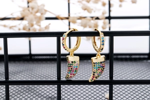 Detail of gold hoop earrings with crescent pendants and colorful pave zircon crystals