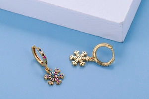 Close-up of golden snowflake earrings featuring vibrant multi-color zircon stones