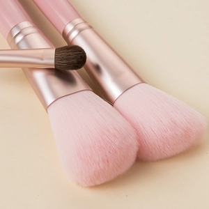 Detailed view of pink makeup brushes with rose gold ferrules and soft bristles