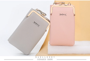 Detail of grey and pink PU leather crossbody phone bags with lychee texture and kiss-lock