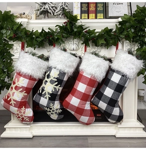 Close-up of four plaid Christmas stockings with white faux fur hanging on a cozy fireplace