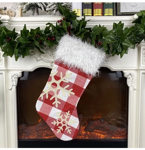 Detail of red and white plaid Christmas stocking with snowflakes and faux fur trim