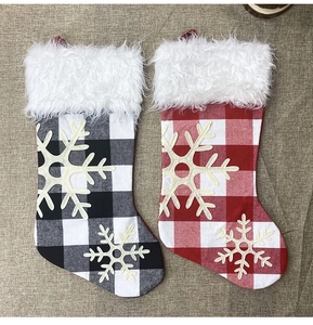 Close-up of red and black plaid Christmas stockings with faux fur cuffs and snowflake appliques
