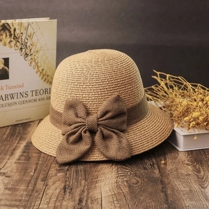Straw sun hat for women with bow decoration in a summer vacation bucket hat style