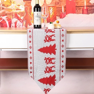 Detail of knitted Christmas table runner with reindeer pattern in festive dining scene