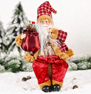 Detail of sitting Santa doll with red plaid hat, white beard and velvet pants on snow