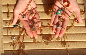 Detailed close-up of rainbow zircon evil eye and star jewelry held in hands
