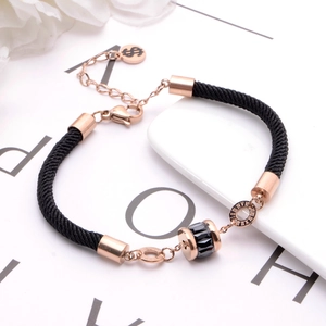 Black woven cord bracelet with rose gold beads and Roman numeral charm details