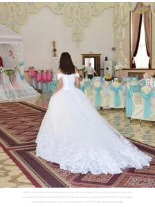 Detailed embroidery on white off-the-shoulder lace wedding dress with a long train