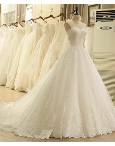Dettaglio dello scollo a cuore e dei ricami floreali in pizzo sull'abito da sposa avorio