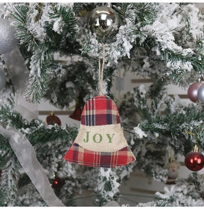 Détail d'ornement de Noël en forme de cloche avec texte Joy sur sapin enneigé