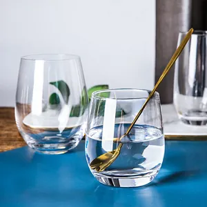 Dettaglio di un elegante bicchiere di cristallo a forma di uovo con lungo cucchiaio d'oro