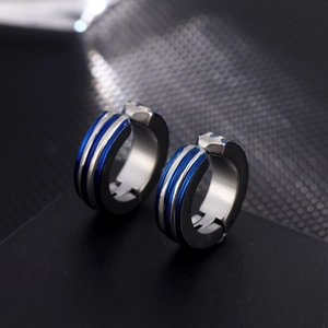 Macro shot of silver and blue striped stainless steel clip-on earrings for men