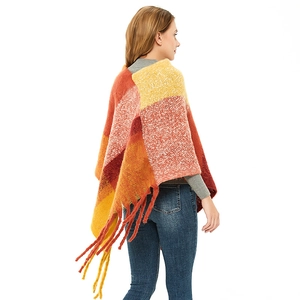 Women's plaid knitted poncho cape with warm tones, thick fringe tassels, and a loose fit