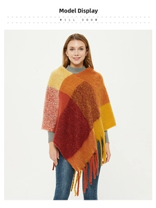 Detail of colorful plaid pattern and long fringe on the warm winter knitted shawl poncho