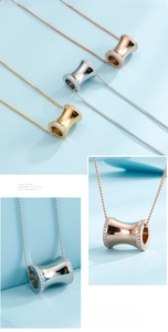 Close-up of triple-colored cylinder pendants with mirror finish and cubic zirconia inlay