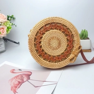 Handcrafted round rattan crossbody bag with wave pattern and leather shoulder strap
