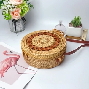 Handcrafted round rattan crossbody bag with brown leather strap in bohemian woven style