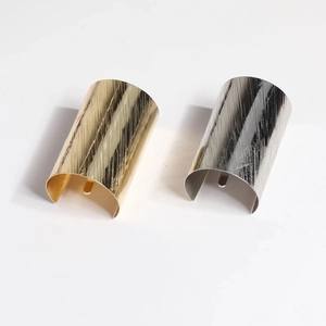 Minimalist brushed metal ponytail hook fasteners in gold and silver finish on white background