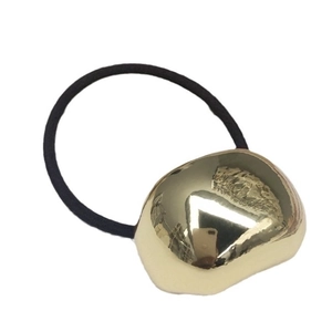 Elastic black hair tie with irregular gold metallic block on a clean white background