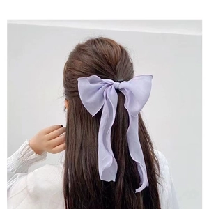 Elegant light purple chiffon bow hair tie with long ribbons on brunette wavy hair