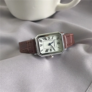 Detailed macro view of vintage square watch with brown leather strap and Roman numerals