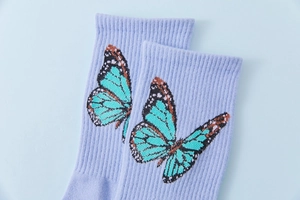 Close-up of purple combed cotton socks with butterfly pattern and ribbed cuffs